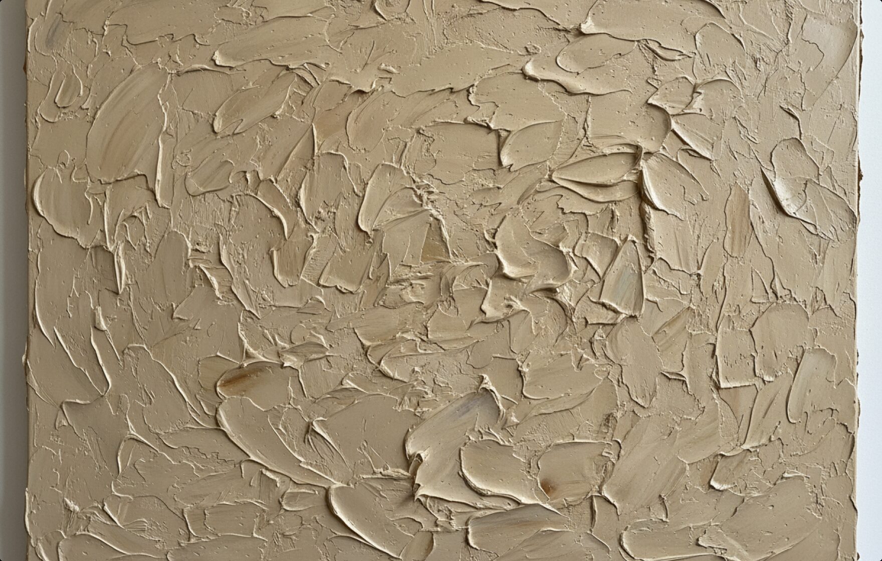 Textured plaster artwork in beige tones